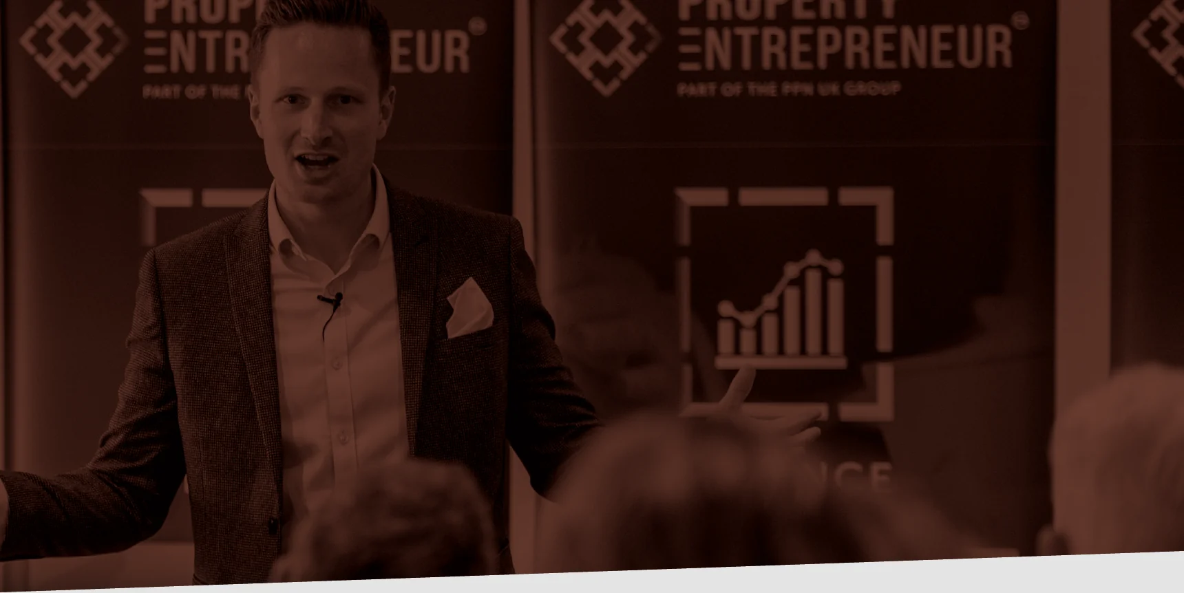 Josh Keegan presenting on stage at a Property Entrepreneur event